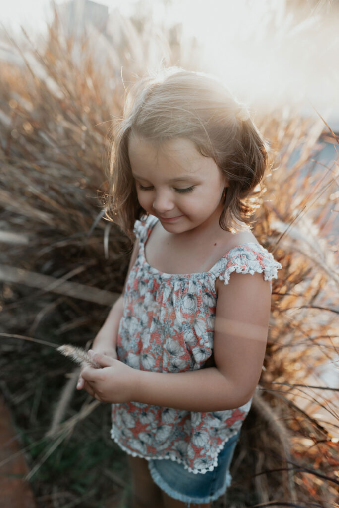Girl sitting in the tall dune grass – family photos in the dunes of Bloemendaal
