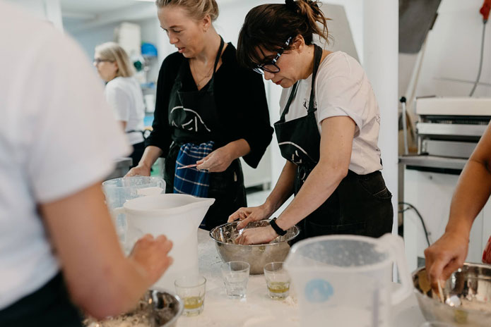 Participants kneading dough together during a hands-on cooking workshop