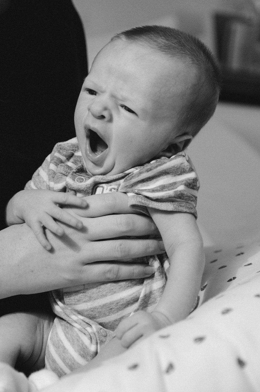 Newborn yawning in a parent's hands – unposed newborn photos in Haarlem