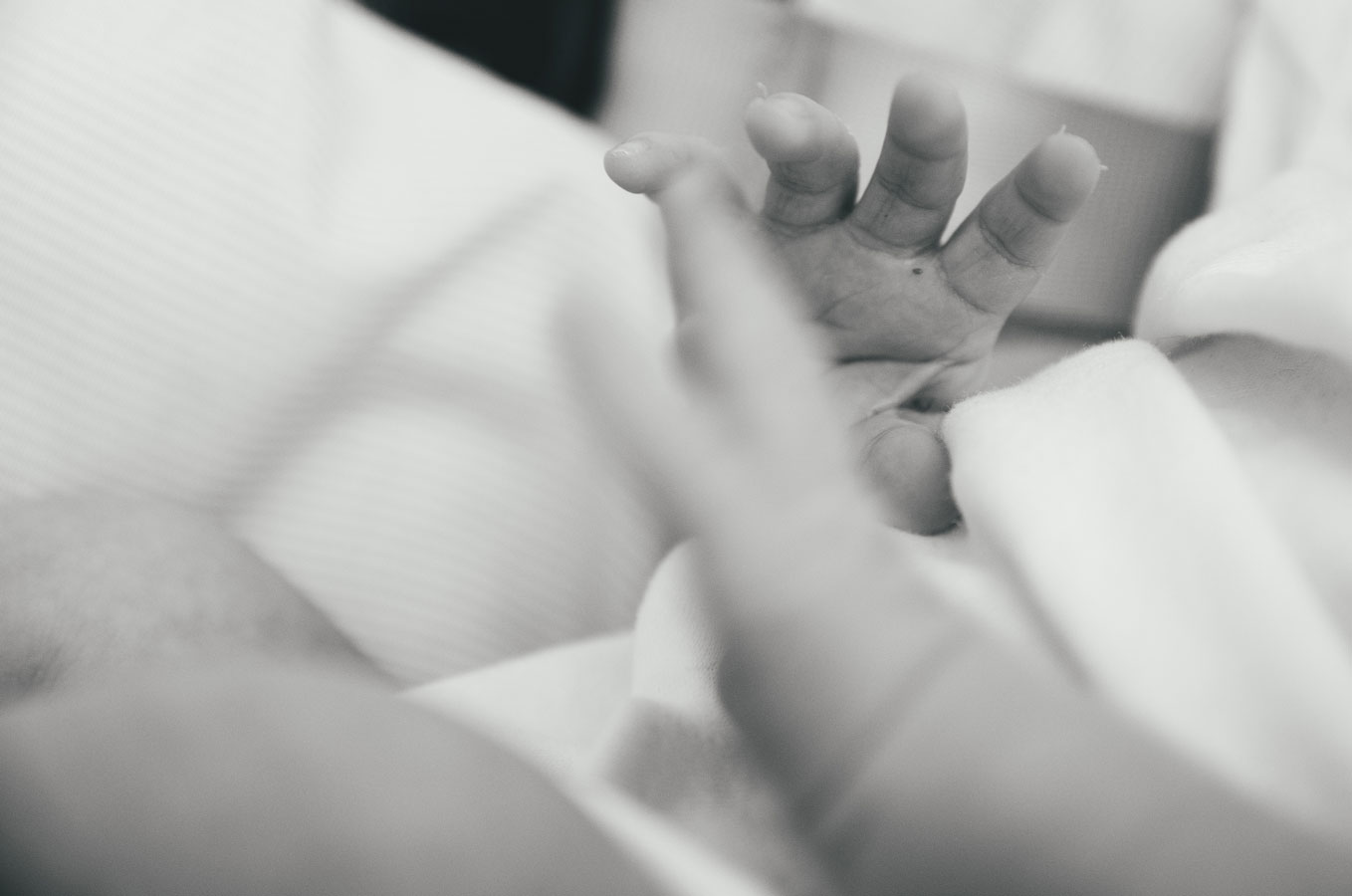 Tiny newborn hand reaching out – close-up detail from a newborn session at home