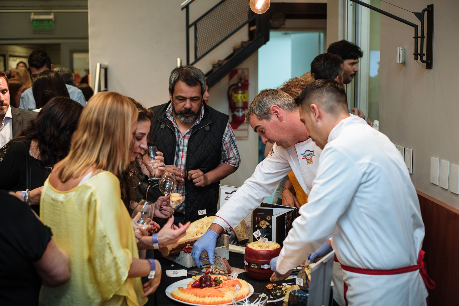 Chefs serving cheese to guests at a food and wine tasting event