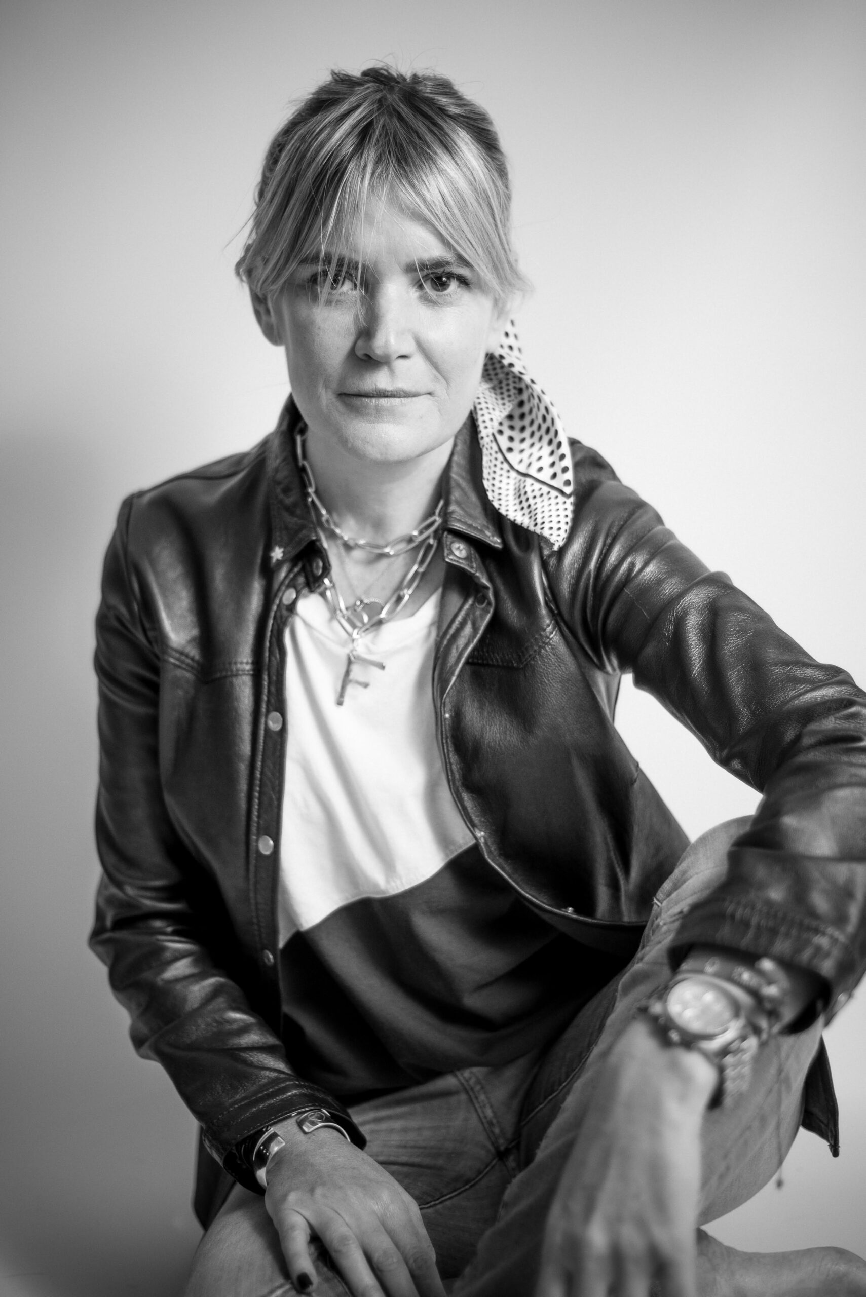 Woman in a leather jacket, black and white portrait on a light background