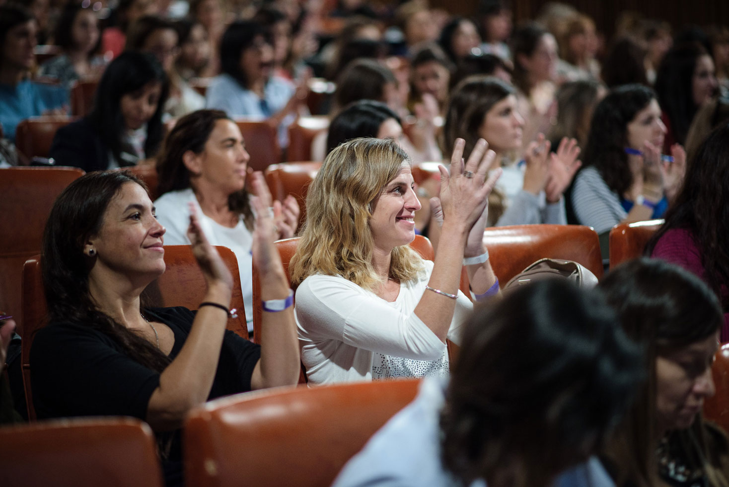 Audience smiling and applauding during a conference talk
