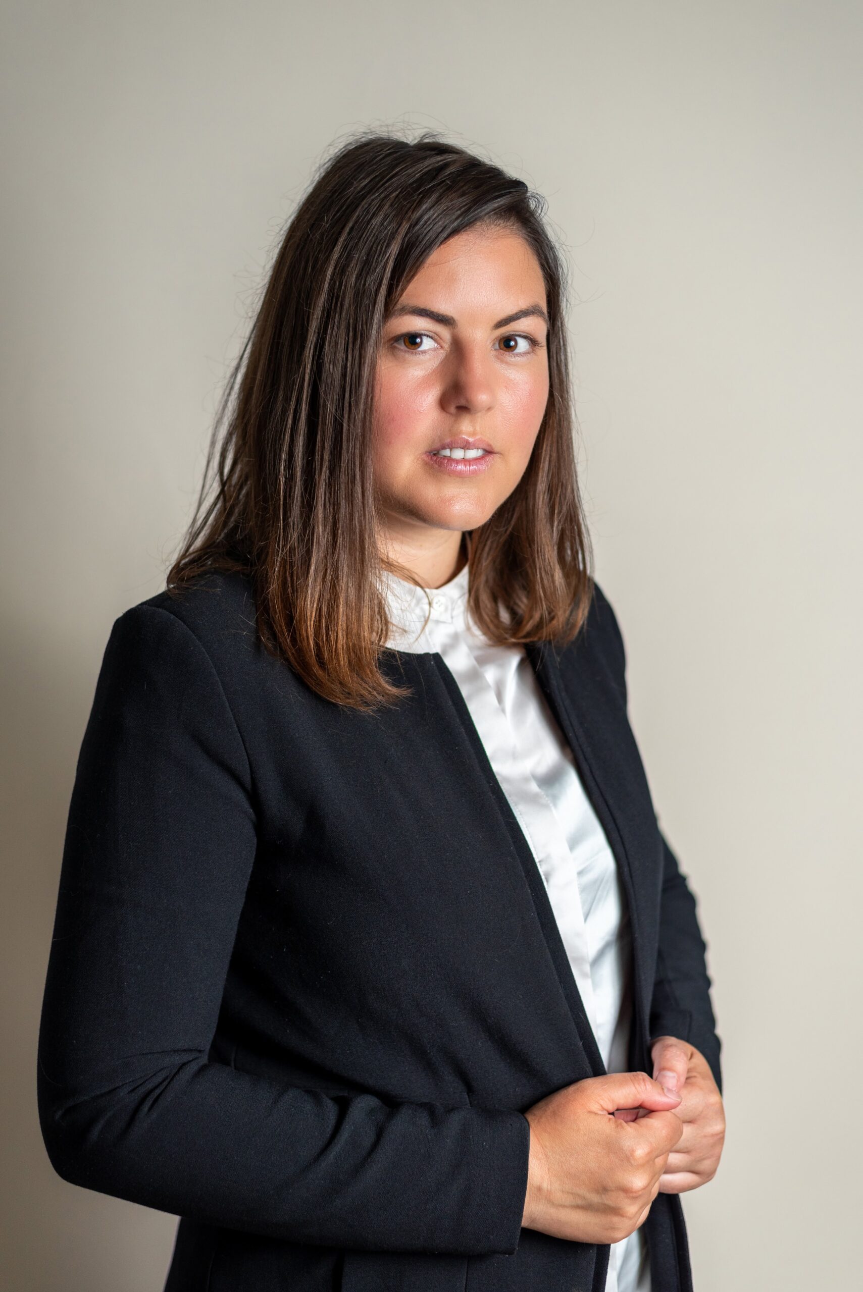 Woman in a black knit sweater, portrait on a light background