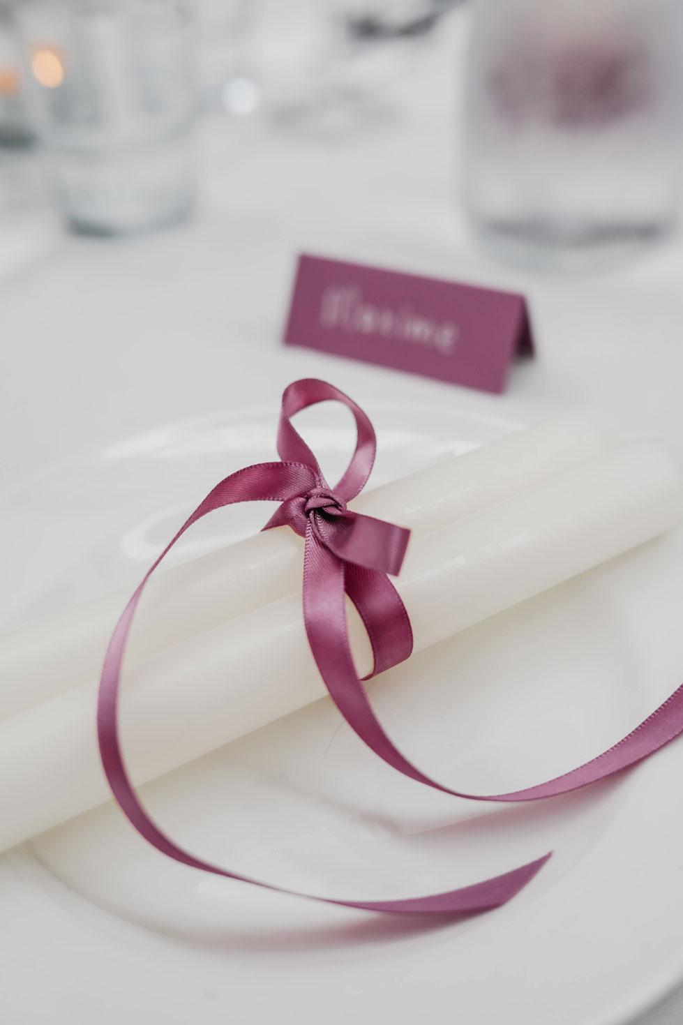 Close-up of white candles tied with a pink satin ribbon, a gift for each baby shower guest