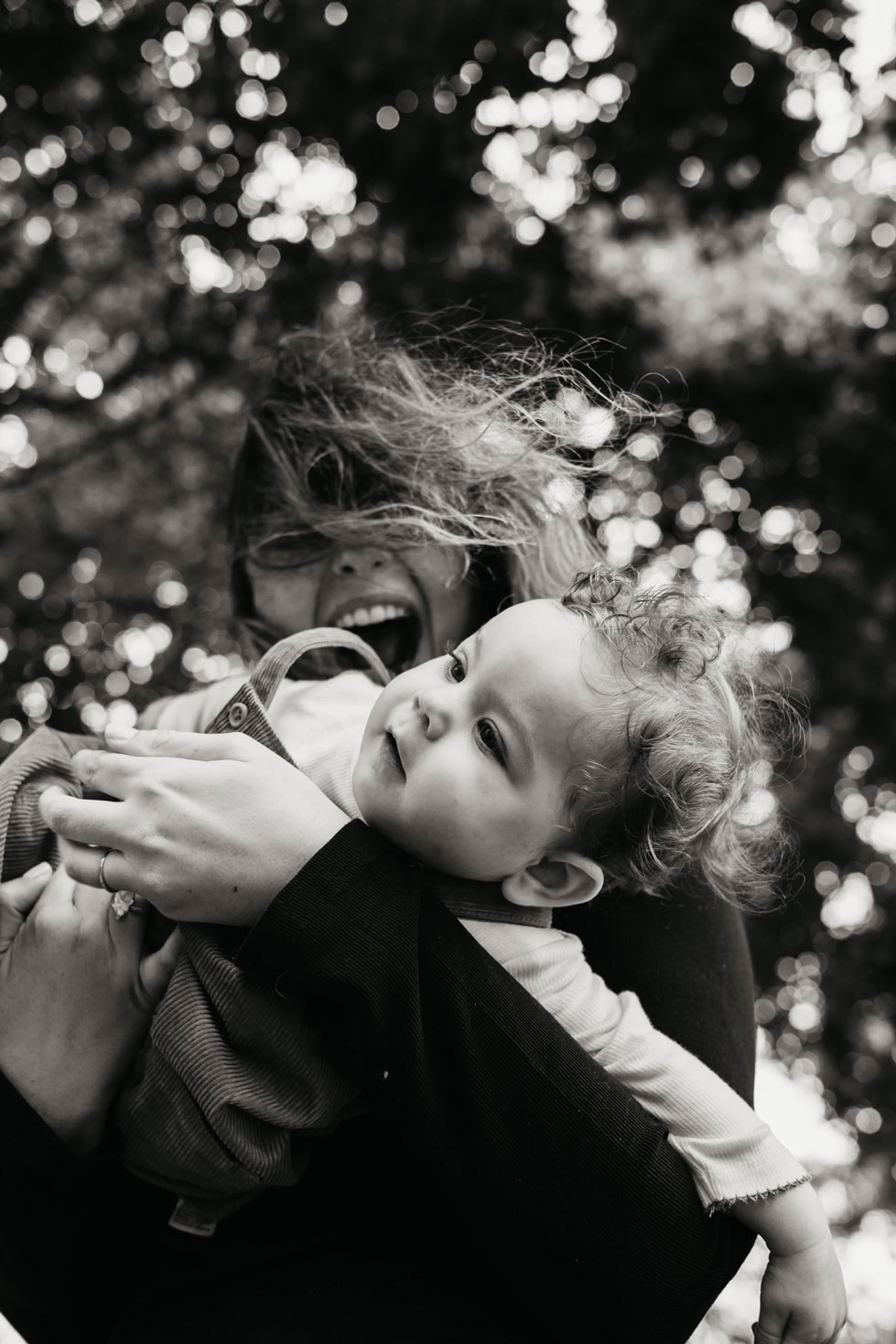 Mother smiling at her curly-haired baby in Westerpark, Amsterdam